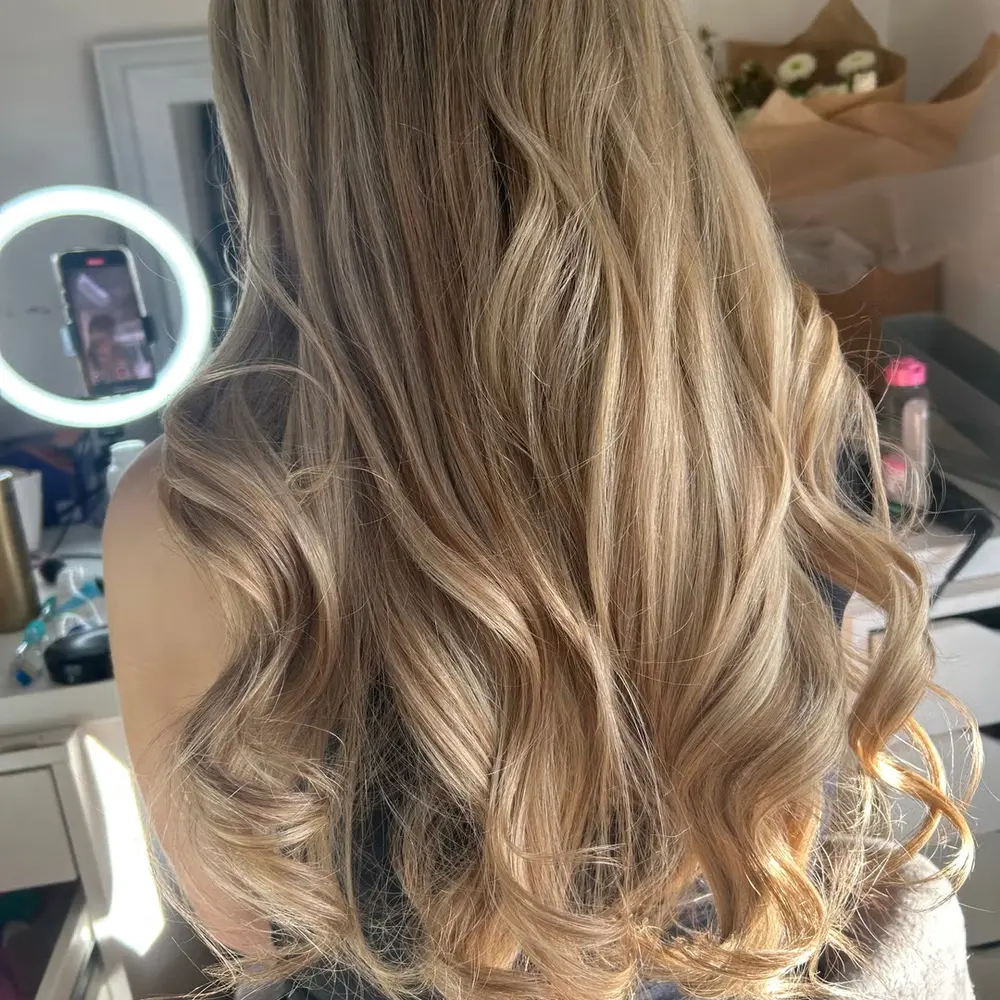 Long wavy blonde balayage with soft, lived-in dimension