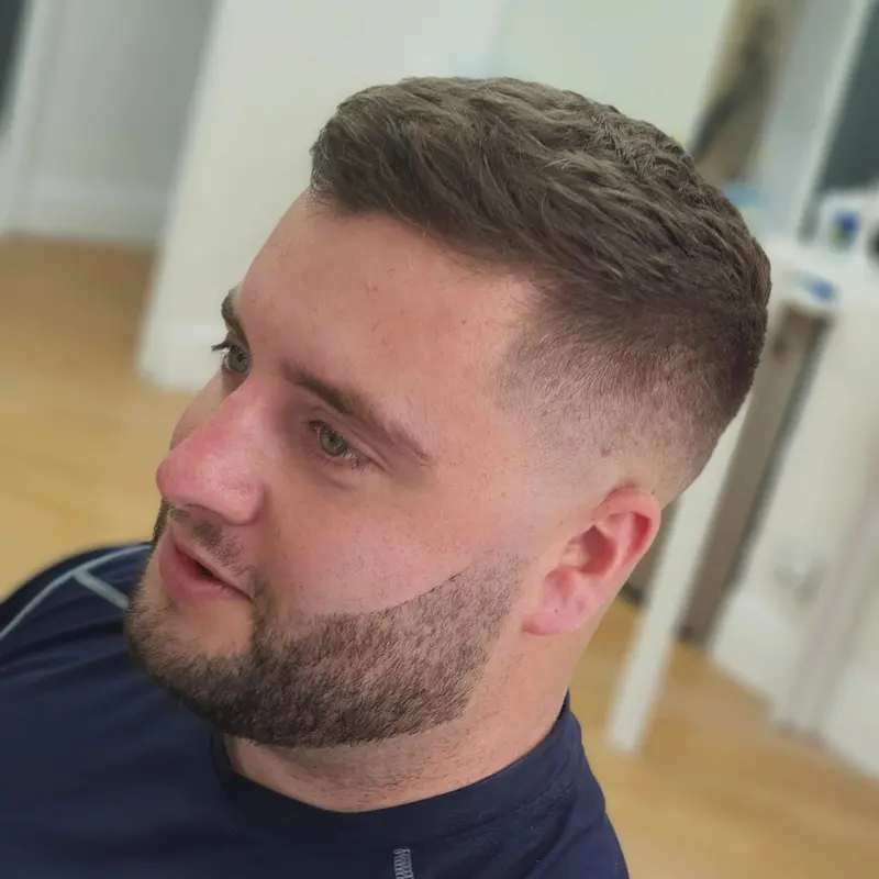 Men's textured crop with a clean skin fade and beard shape